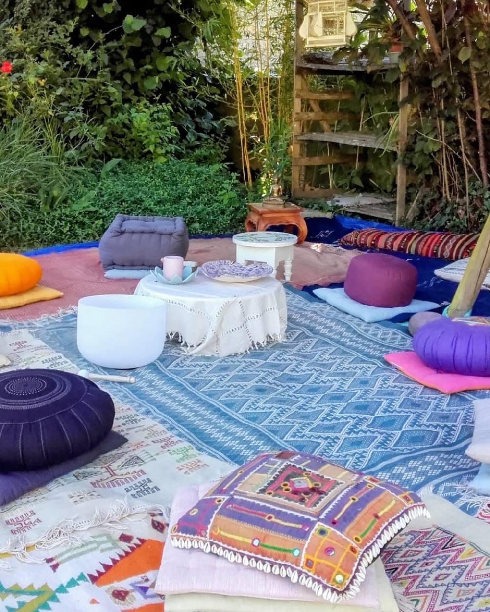 Espace du cercle de femmes installé dans un jardin : coussins, tapis et bol chantant
