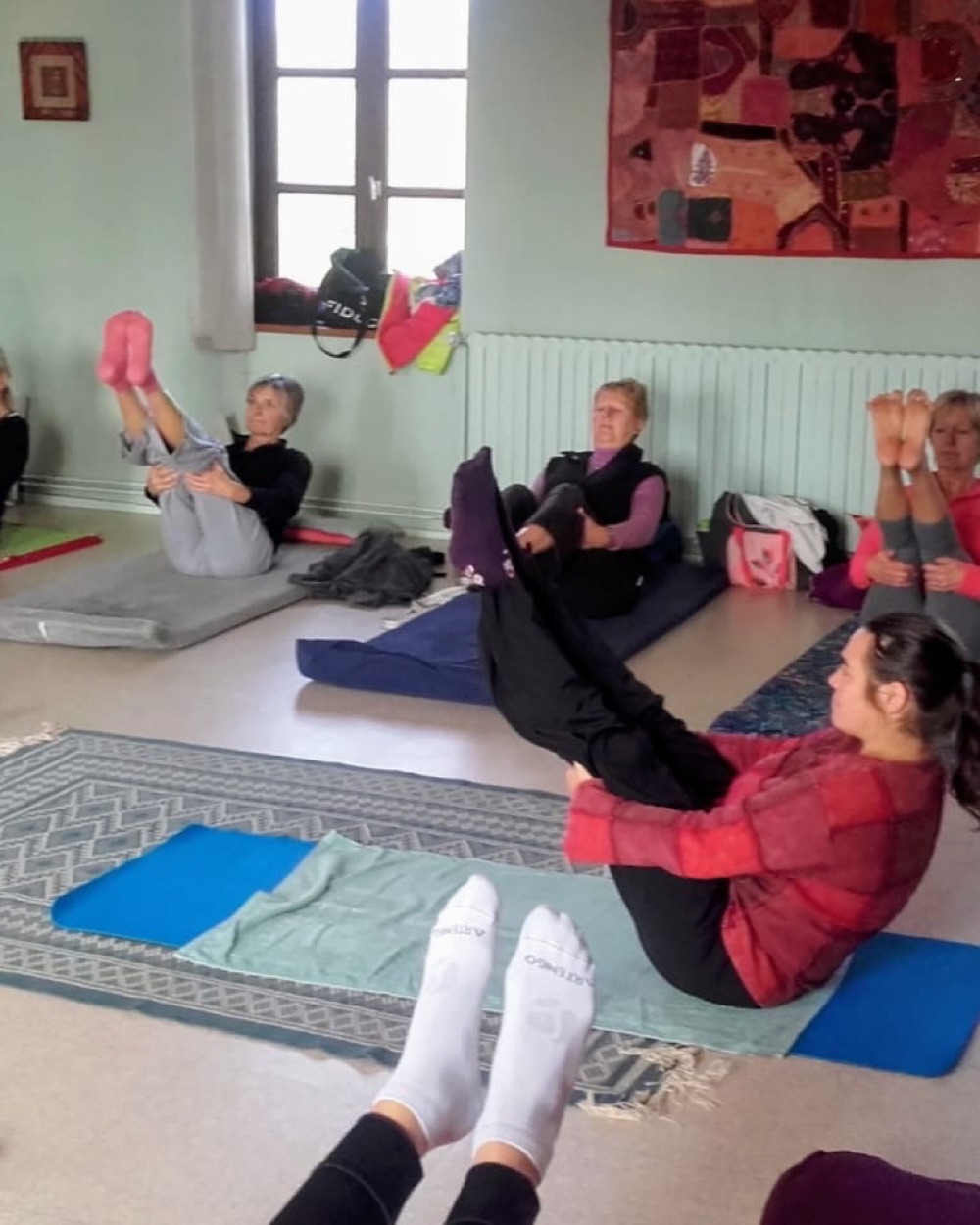 Cours de Hatha Yoga en groupe dans la salle, posture du bateau